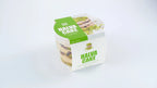 Halva cake with pistachio and chocolate in branded plastic container on white background