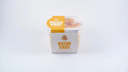 Halva cake with caramel and hazelnut in branded plastic packaging on white background
